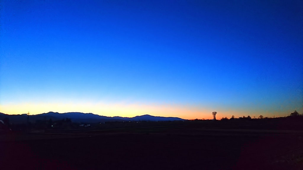 日の出前、オレンジからブルーへのグラデーションに染まる東の空