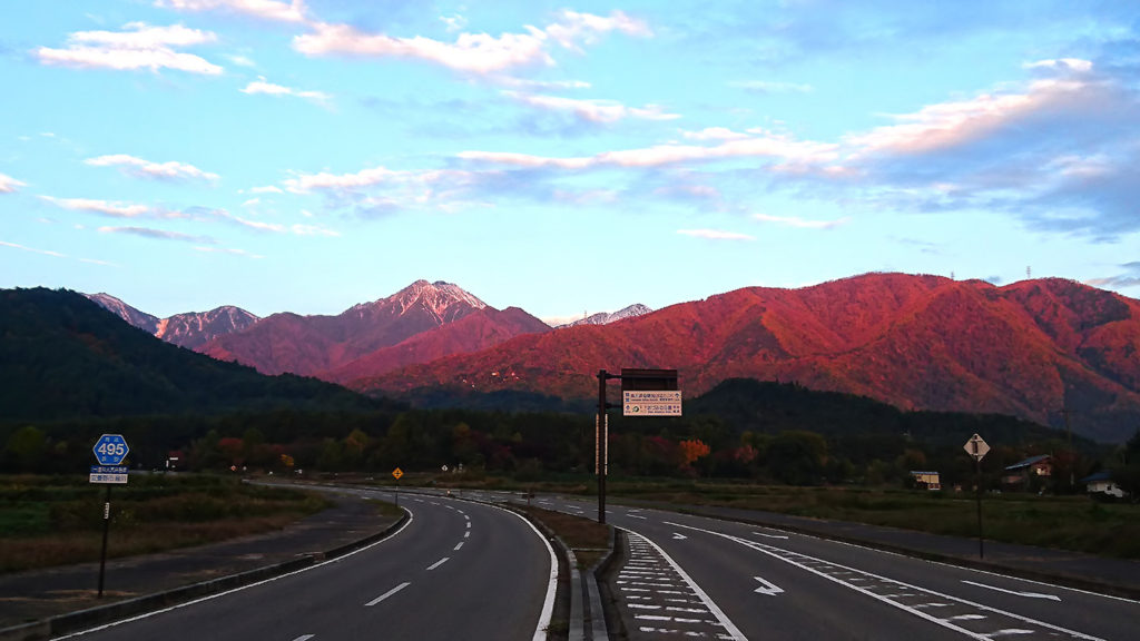 朝日に赤く染まる常念岳方向の山